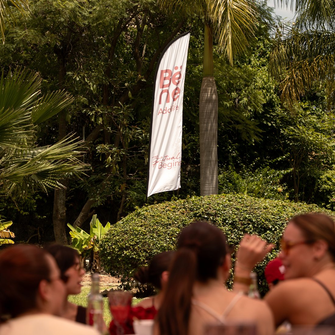 Evento Bëne con el banner de marca y la comunidad reunida