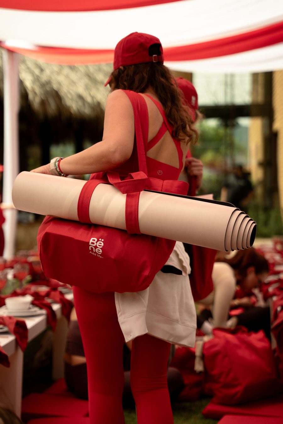 Embajadora con tapete de yoga y maleta roja Bëne